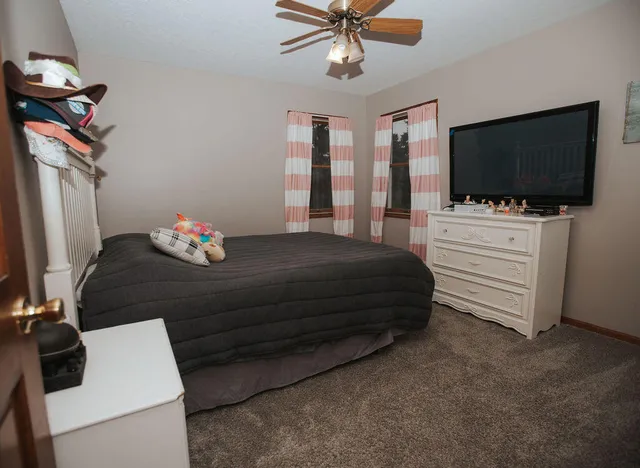 a bedroom with a bed and flat screen tv