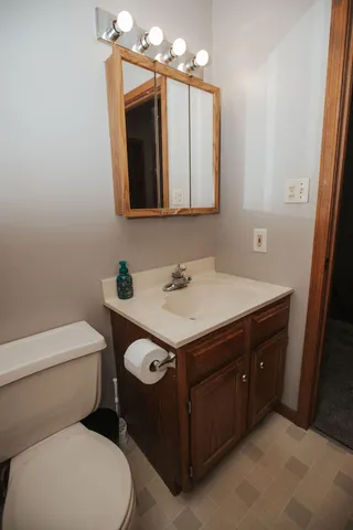 a bathroom with a granite countertop toilet sink and mirror