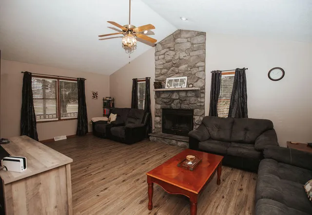 a living room with furniture a fireplace and a flat screen tv