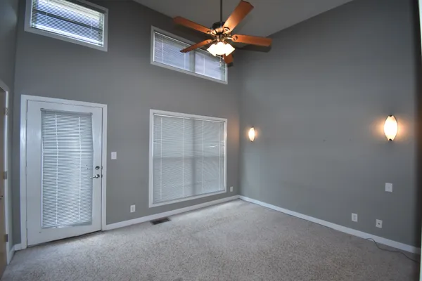 en empty room with windows and a ceiling fan