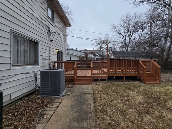a view of a house with backyard and wooden fence