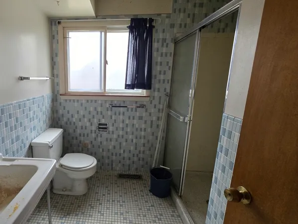 a bathroom with a toilet and a shower