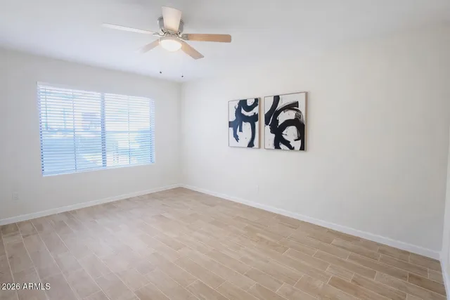 an empty room with windows and fan