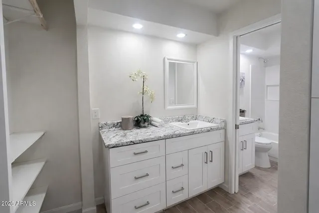 a bathroom with a granite countertop sink and a mirror