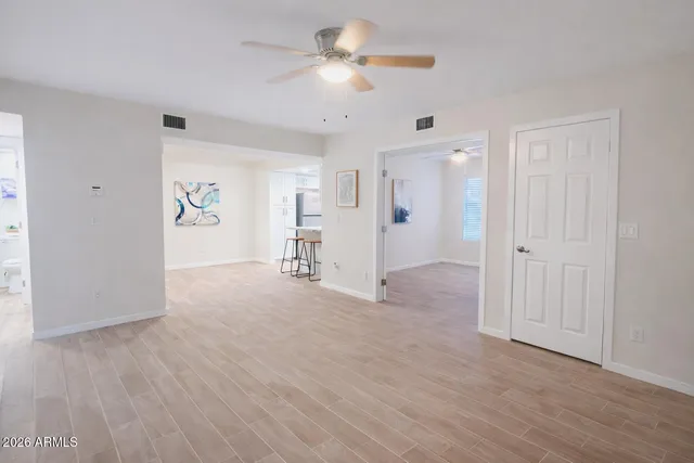 a view of a livingroom with a furniture chandelier fan and hardwood floor