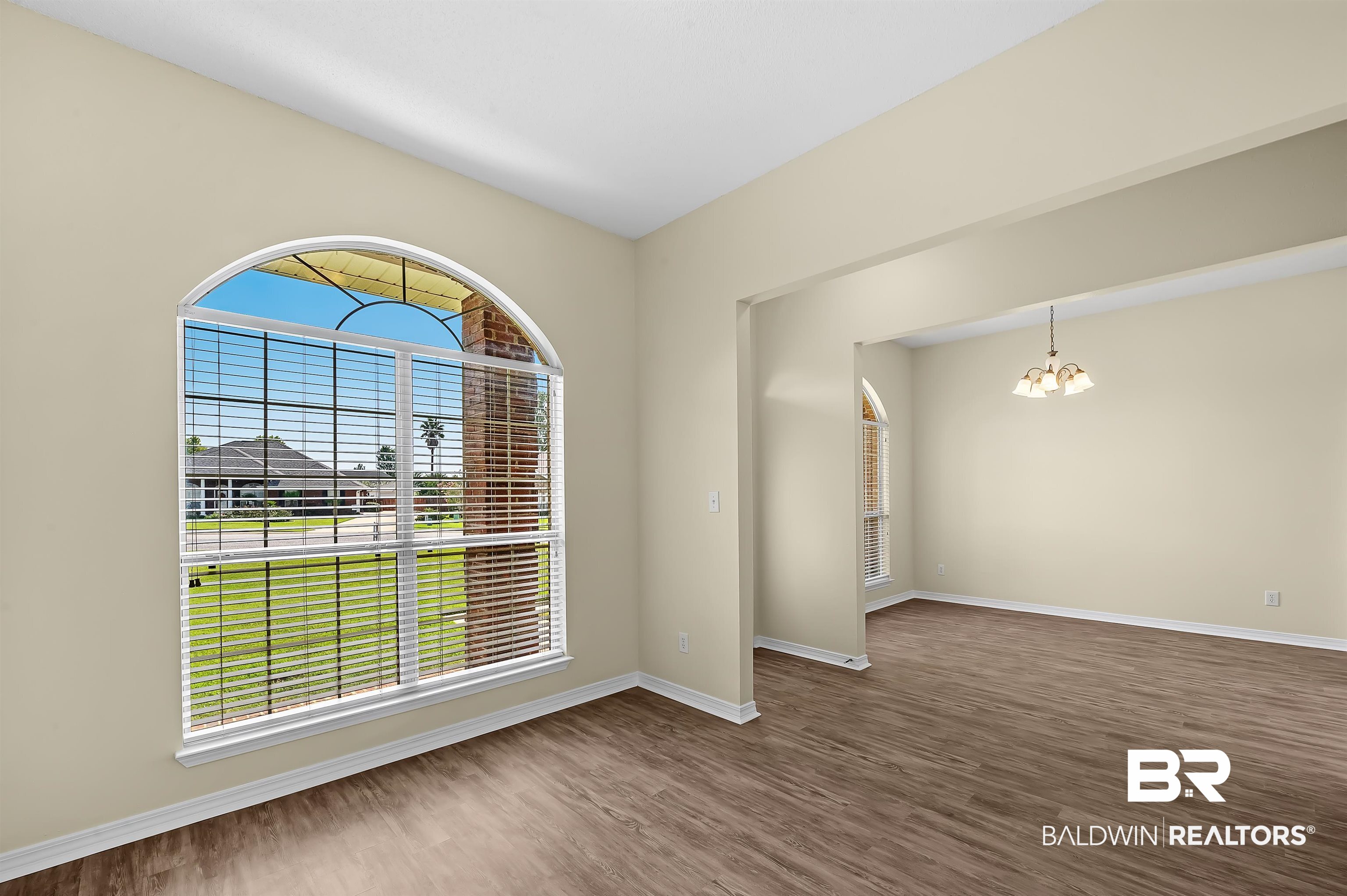 12443 Venice Boulevard Foley, AL 36535 - Photo 16 of 59 Unfurnished room with hardwood / wood-style flooring and a notable chandelier