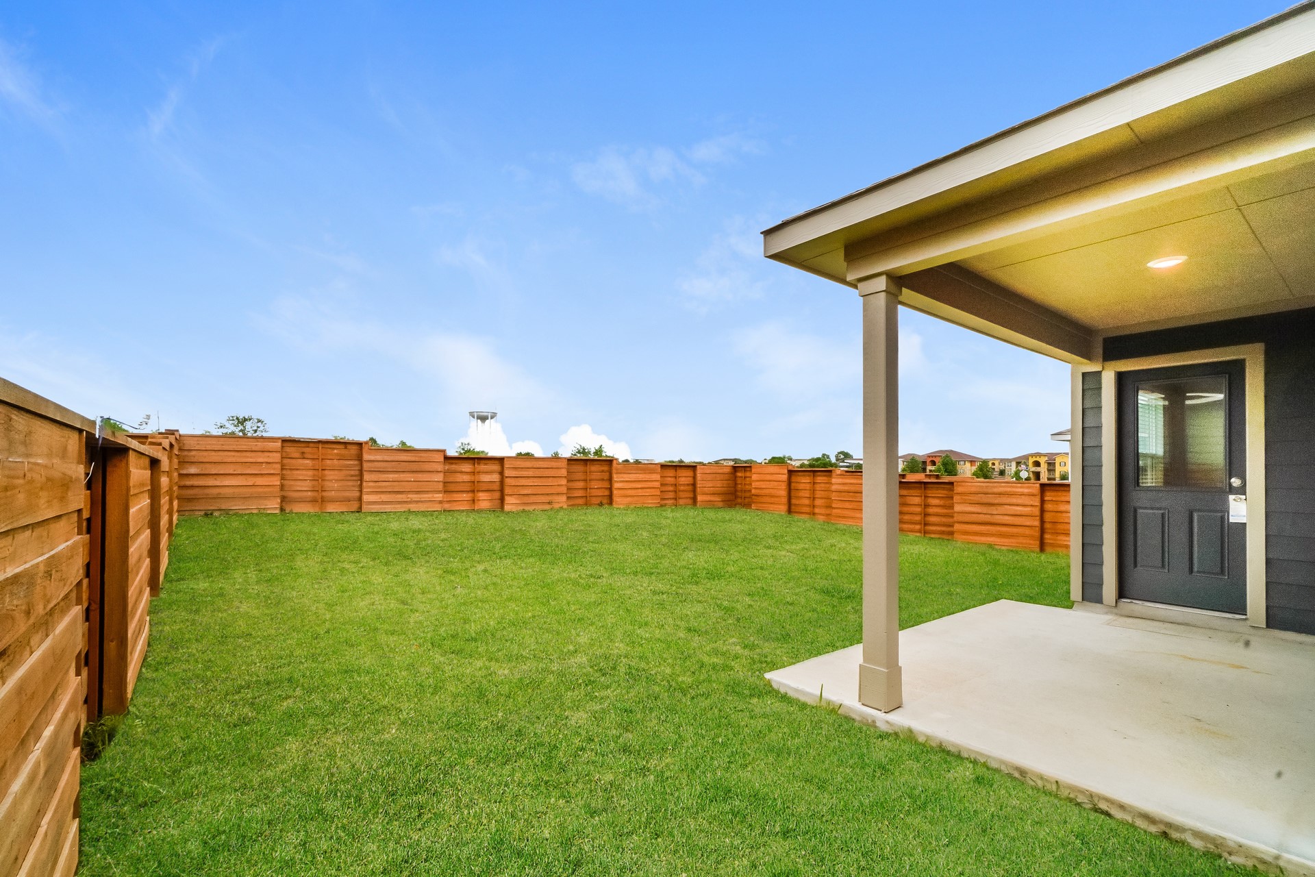 341 Madrid Kyle, TX 78640 - Photo 5 of 27 A secluded backyard with a spacious lawn awaits, perfect for private outdoor enjoyment.