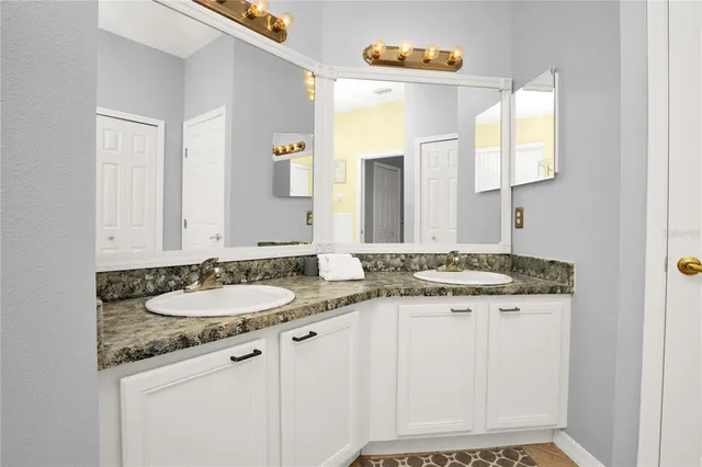 a bathroom with a granite countertop sink and a mirror