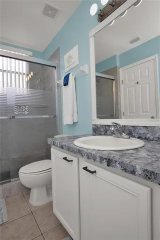 a bathroom with a granite countertop sink a toilet and a mirror