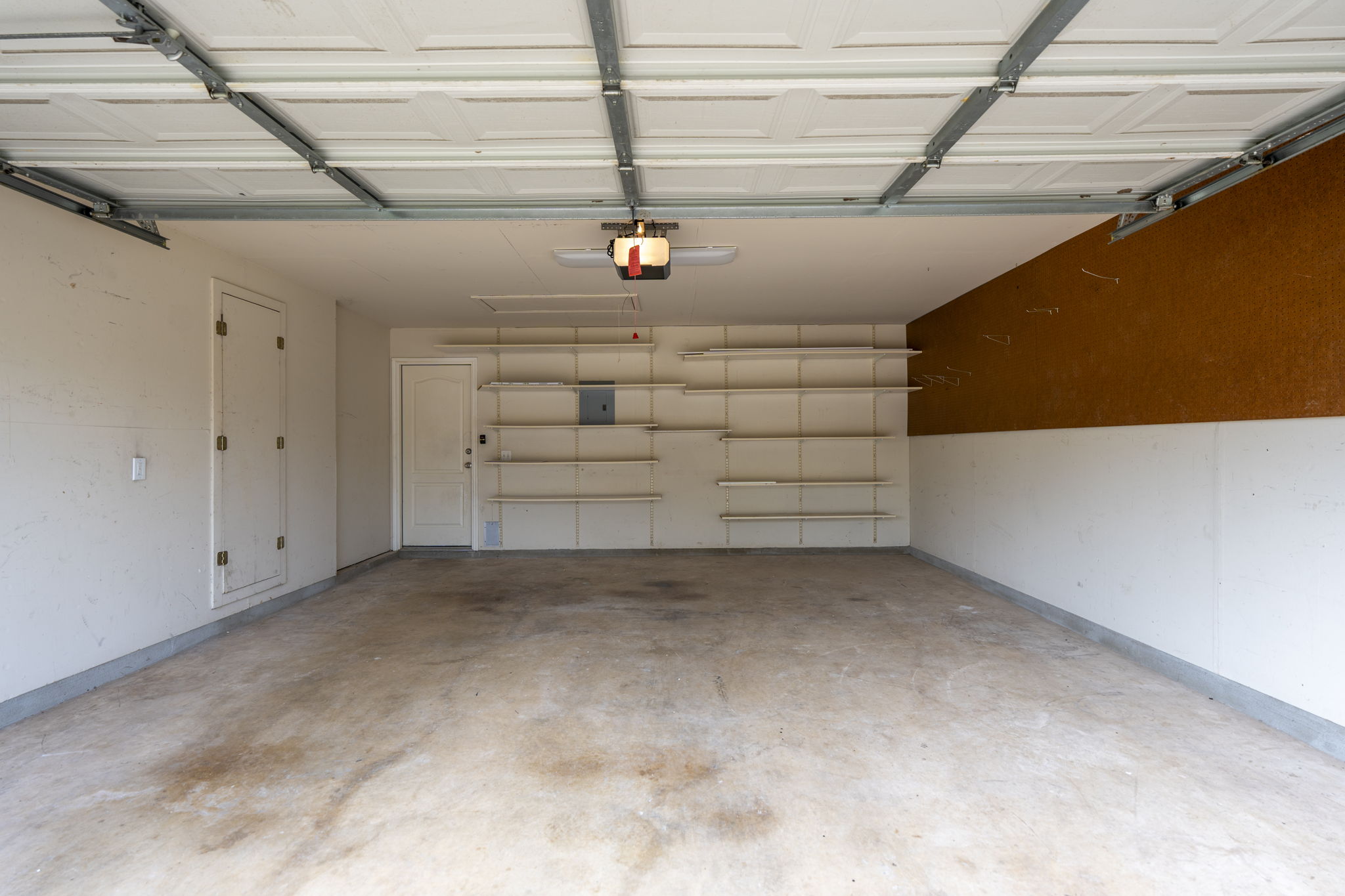 7172 Ridge Oak Road Austin, TX 78749 - Photo 38 of 40 A spacious and organized garage features extensive built-in shelving for optimal storage solutions.