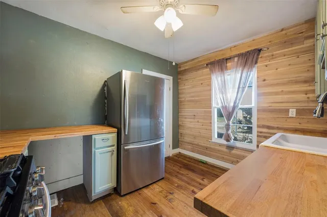 a kitchen with kitchen island a large window appliances and cabinets