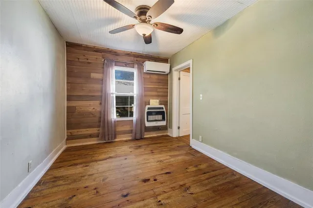 a view of empty room with wooden floor and ceiling fan