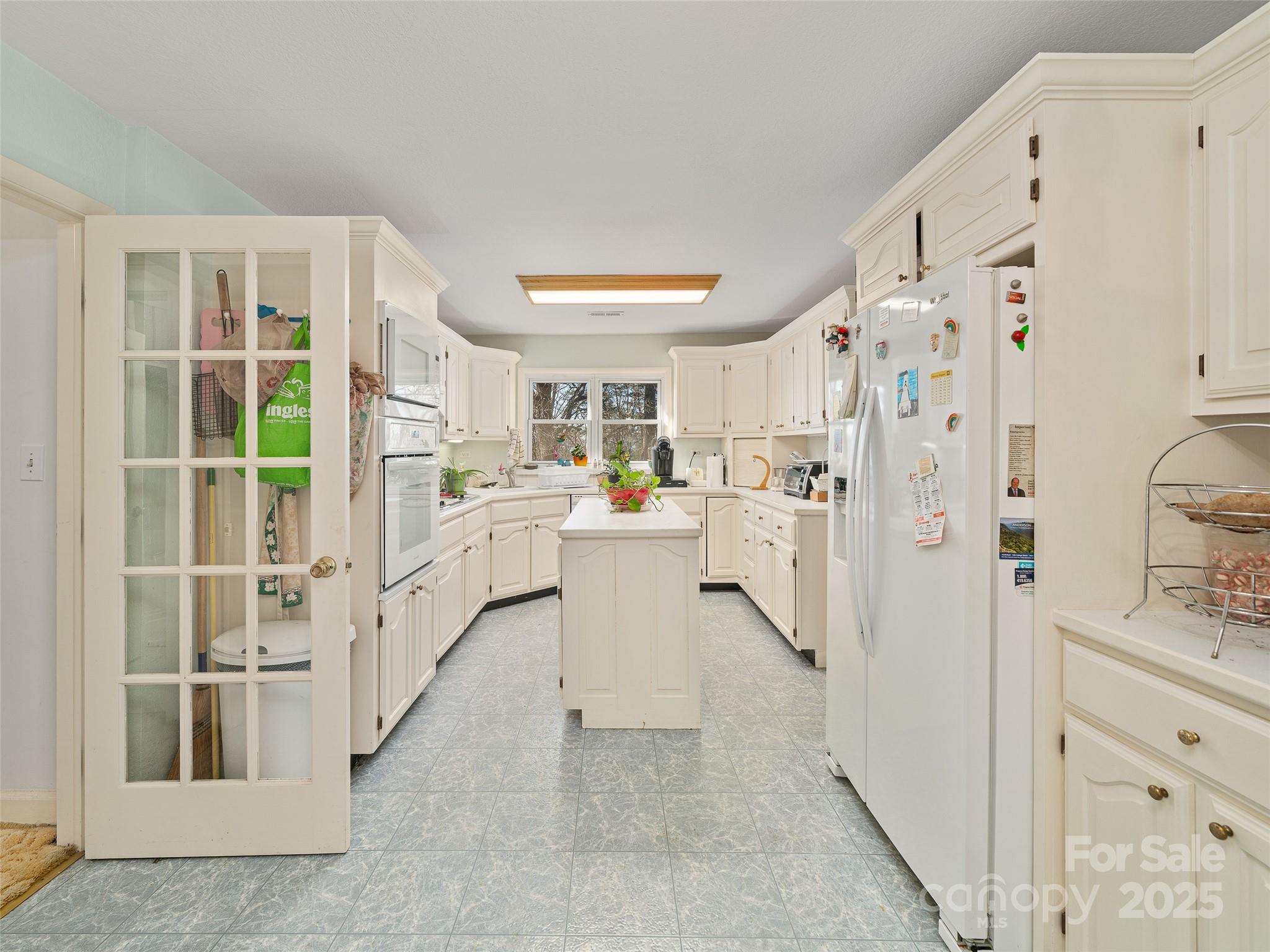 35 Smith Rdg Drive Asheville, NC 28803 - Photo 6 of 38 a kitchen with white cabinets and white appliances