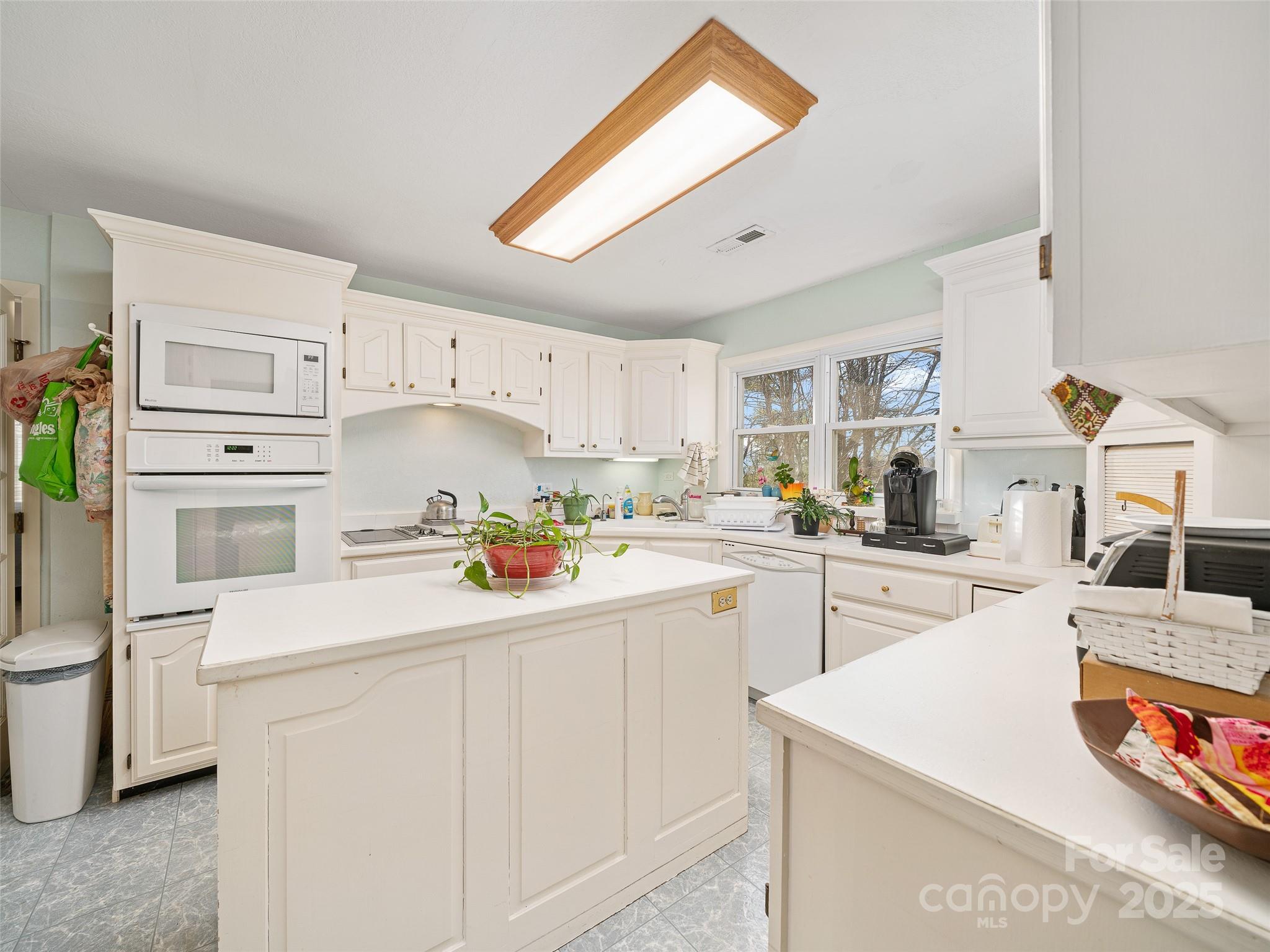 35 Smith Rdg Drive Asheville, NC 28803 - Photo 8 of 38 a kitchen with stainless steel appliances kitchen island granite countertop a sink a stove a refrigerator and white cabinets