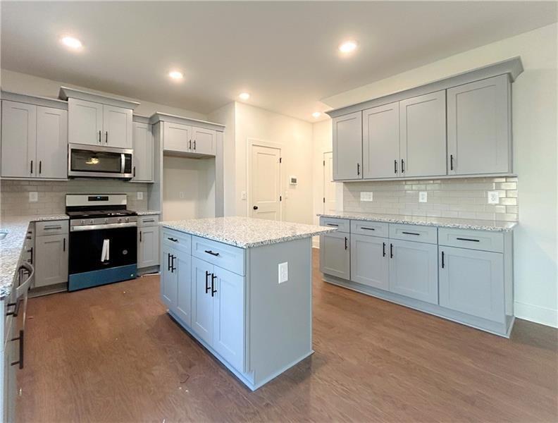 27 Bridgestone Way Cartersville, GA 30120 - Photo 12 of 31 a white kitchen with stainless steel appliances granite countertop a stove a sink a refrigerator and white cabinets
