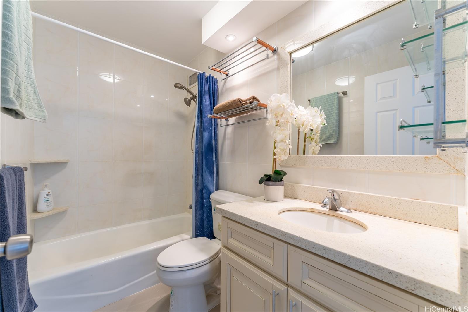 949 Ala Nanala Street, Unit 702 Honolulu, HI 96818 - Photo 14 of 23 a bathroom with a sink a toilet and a large mirror