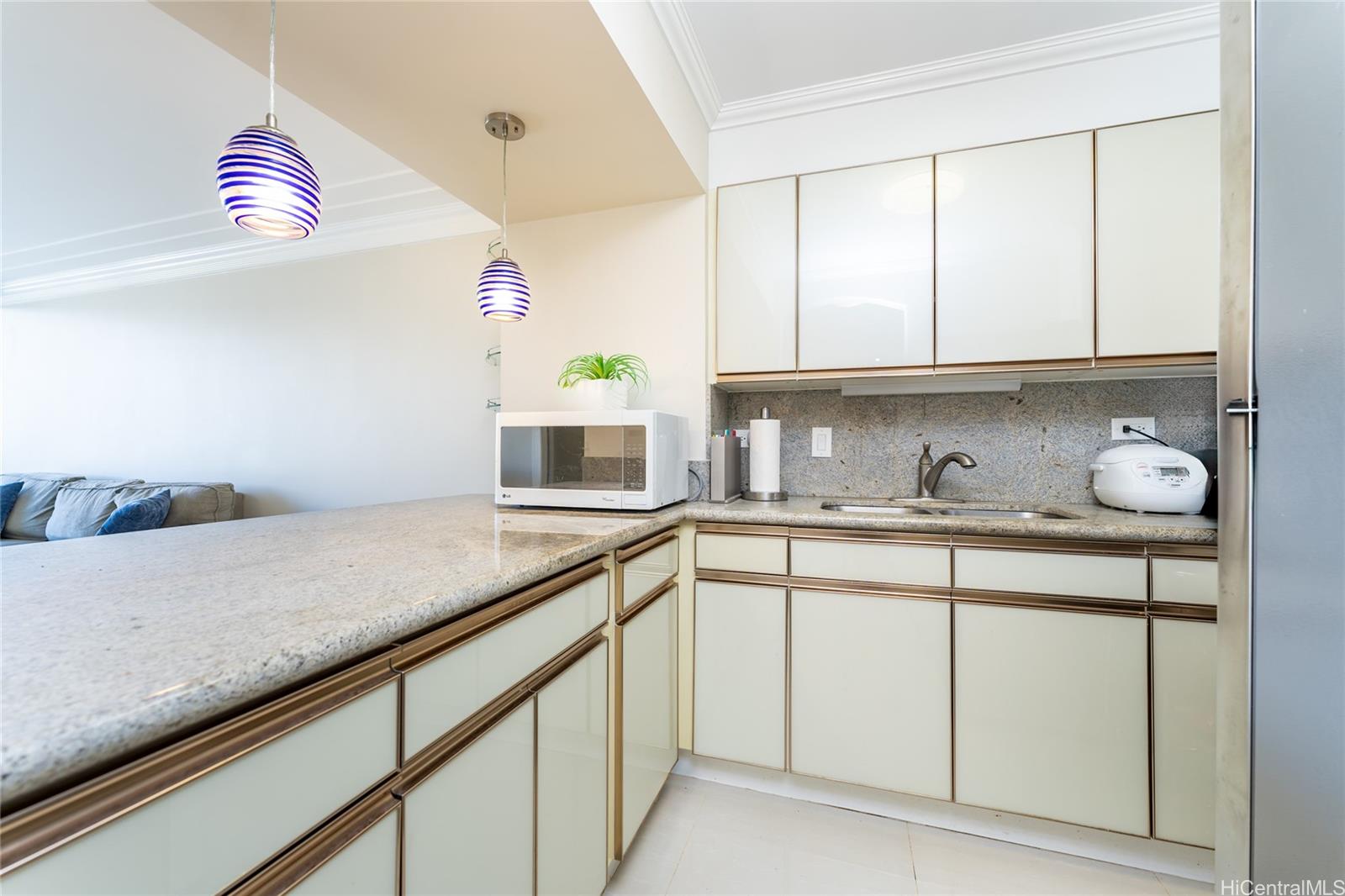 949 Ala Nanala Street, Unit 702 Honolulu, HI 96818 - Photo 5 of 23 a kitchen with granite countertop white cabinets and a sink