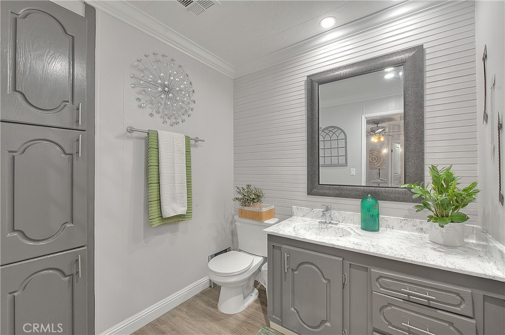 1560 Sir Damas, Unit 159 Riverside, CA 92507 - Photo 12 of 25 a bathroom with a granite countertop sink a toilet and mirror