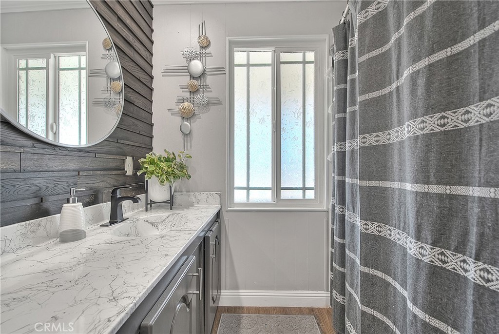 1560 Sir Damas, Unit 159 Riverside, CA 92507 - Photo 4 of 25 a bathroom with a granite countertop shower a mirror and a sink