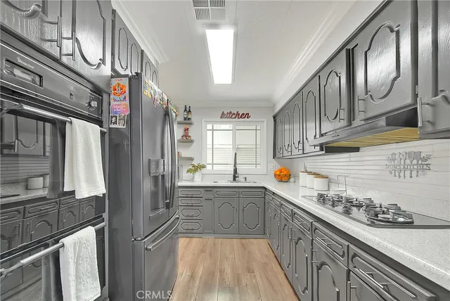 a kitchen with stainless steel appliances granite countertop a lot of counter space and wooden floors