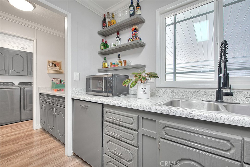 1560 Sir Damas, Unit 159 Riverside, CA 92507 - Photo 9 of 25 a kitchen with kitchen island white cabinets and wooden floor