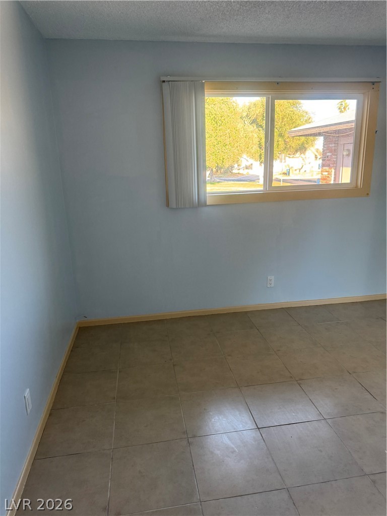 4420 Del Monte Avenue, Unit RENTAL Las Vegas, NV 89102 - Photo 18 of 20 A well-lit room showcasing neutral wall tones and a blend of tile and vinyl flooring.
