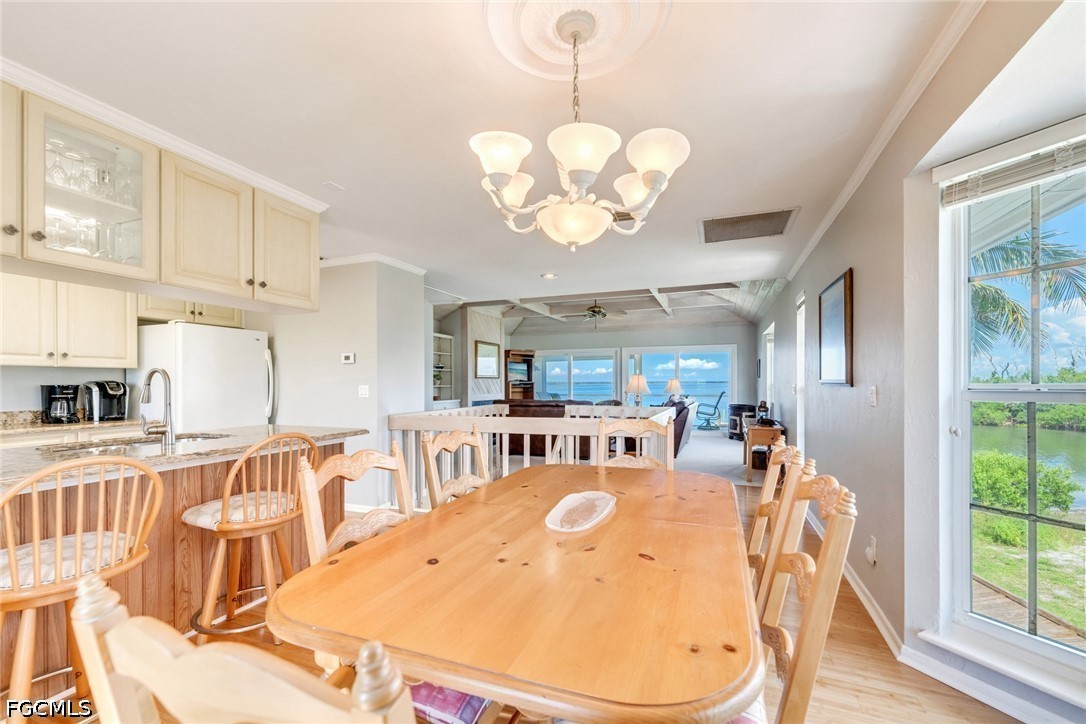 303 Useppa Useppa Island, Unit A Bokeelia, FL 33922 - Photo 44 of 50 a view of a dining room with furniture a chandelier and wooden floor