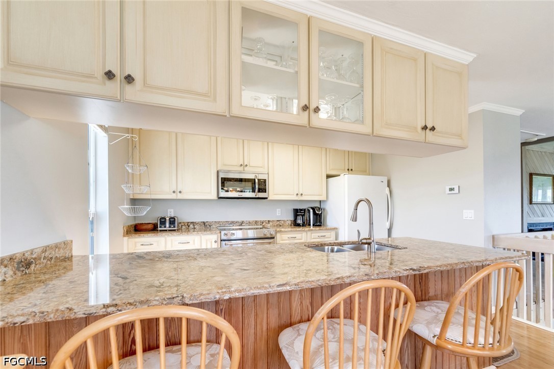 303 Useppa Useppa Island, Unit A Bokeelia, FL 33922 - Photo 45 of 50 a kitchen with stainless steel appliances granite countertop a sink a stove a dining table and chairs with wooden floor