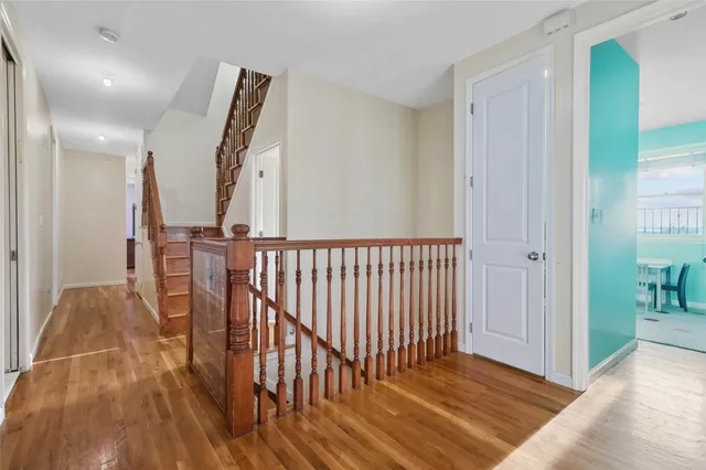 a view of a hallway with wooden floor and staircase