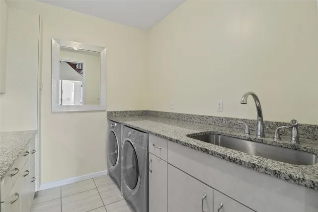 a kitchen with granite countertop a sink and a washer dryer