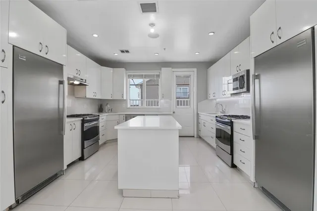 a kitchen with a refrigerator sink and stove