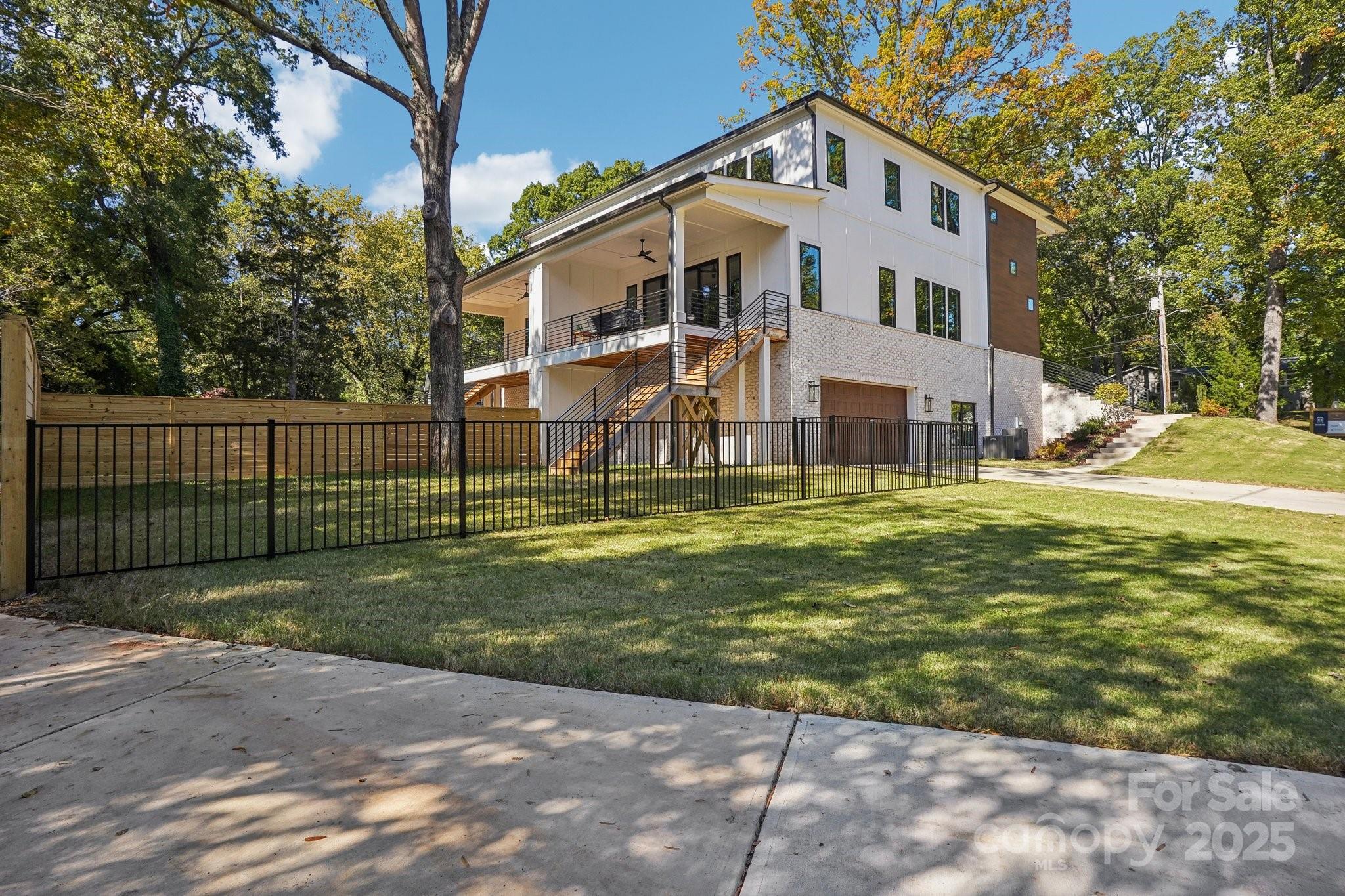 5610 Farmbrook Drive Charlotte, NC 28210 - Photo 41 of 45 a view of a white house with a big yard and large trees