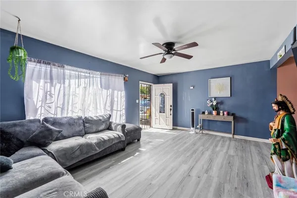 a living room with furniture and a wooden floor