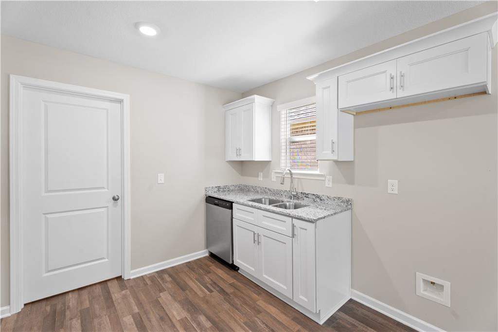 31 Whiterock Road Phenix City, AL 36869 - Photo 22 of 36 Kitchen with white cabinetry, light stone counters, stainless steel dishwasher, and dark wood-style flooring