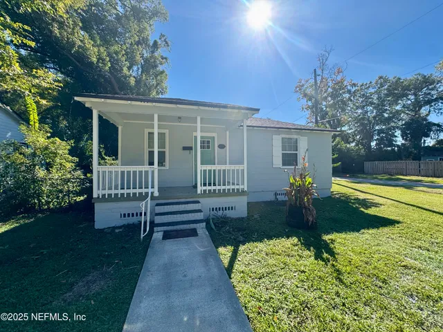 a view of a house with backyard and porch