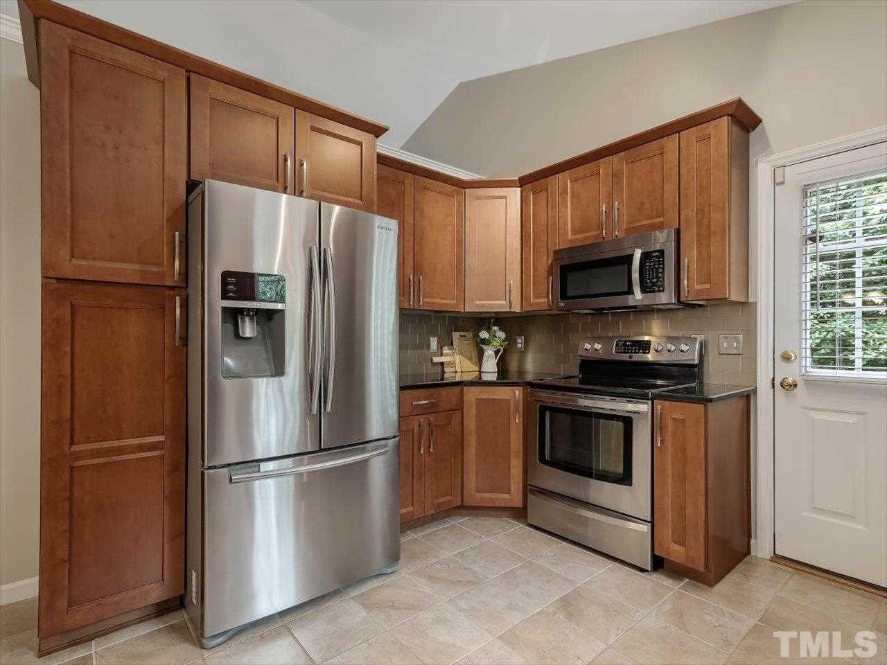 6441 Guess Road Durham, NC 27712 - Photo 11 of 30 a kitchen with stainless steel appliances granite countertop a refrigerator stove a sink dishwasher and microwave