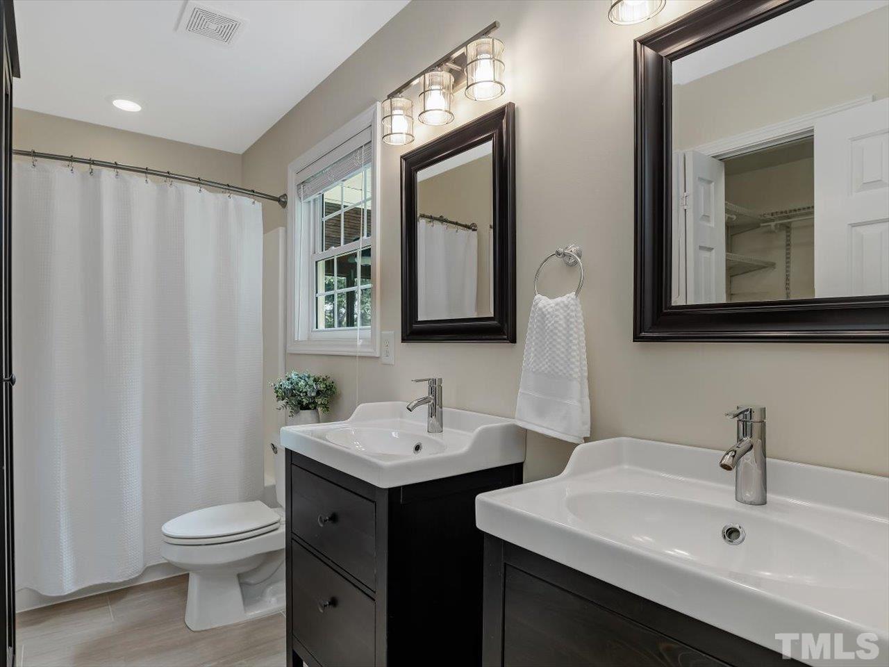6441 Guess Road Durham, NC 27712 - Photo 19 of 30 a bathroom with a toilet a sink and mirror