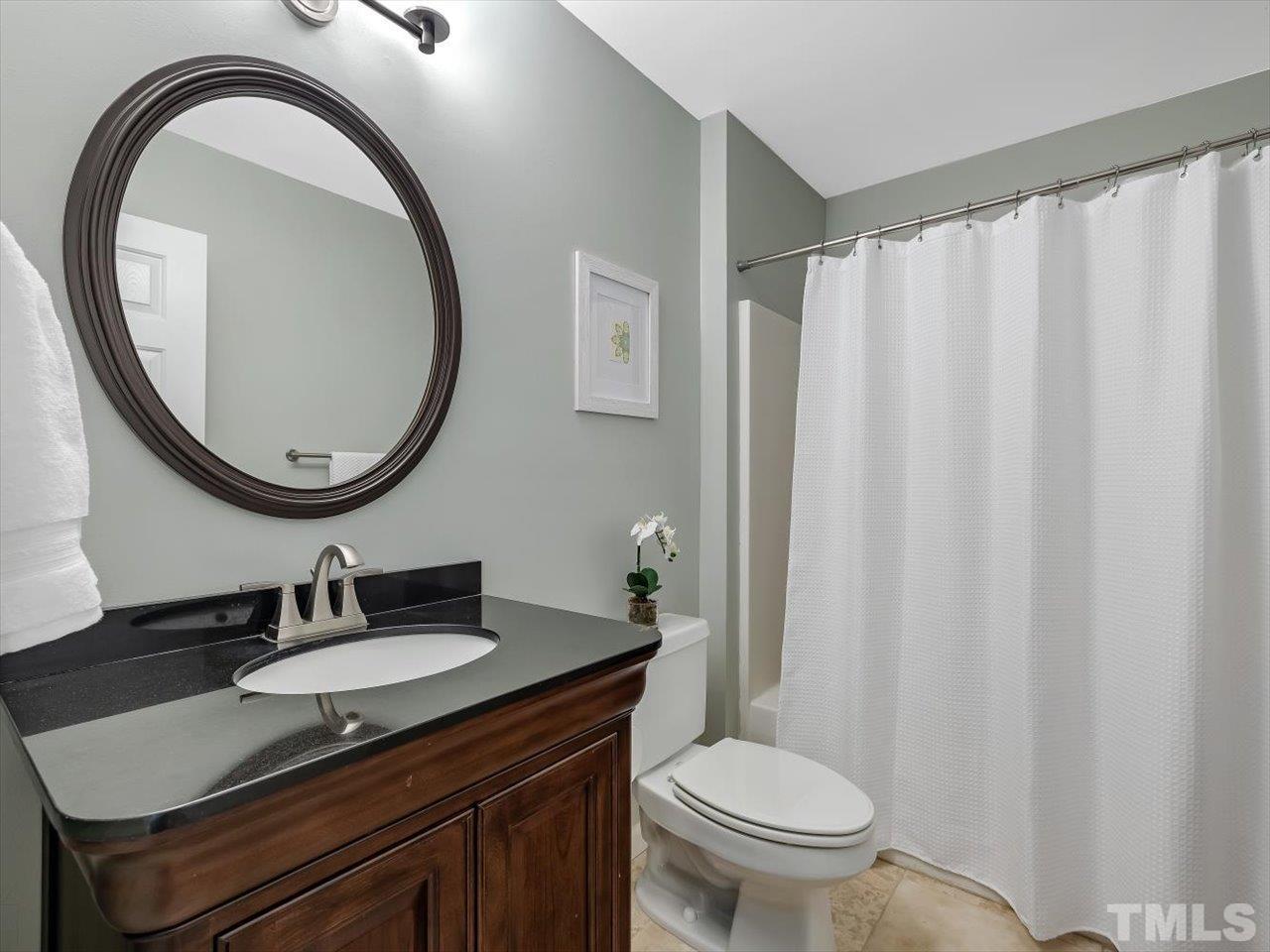 6441 Guess Road Durham, NC 27712 - Photo 21 of 30 a bathroom with a granite countertop sink and a mirror