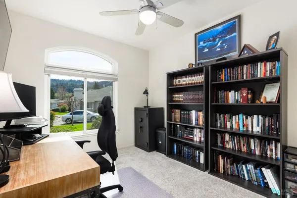 a workspace with furniture bookshelf and a window