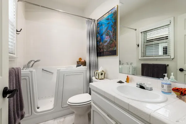 a bathroom with a sink a toilet and shower curtain