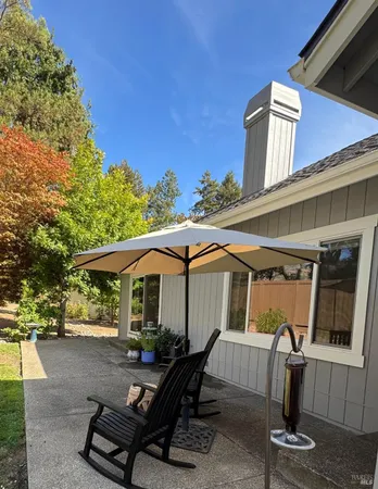 a view of a house with backyard sitting area and garden