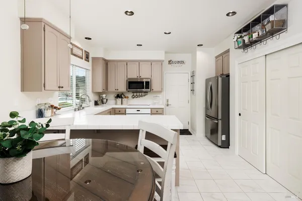 a kitchen with stainless steel appliances a sink a refrigerator and a cabinets