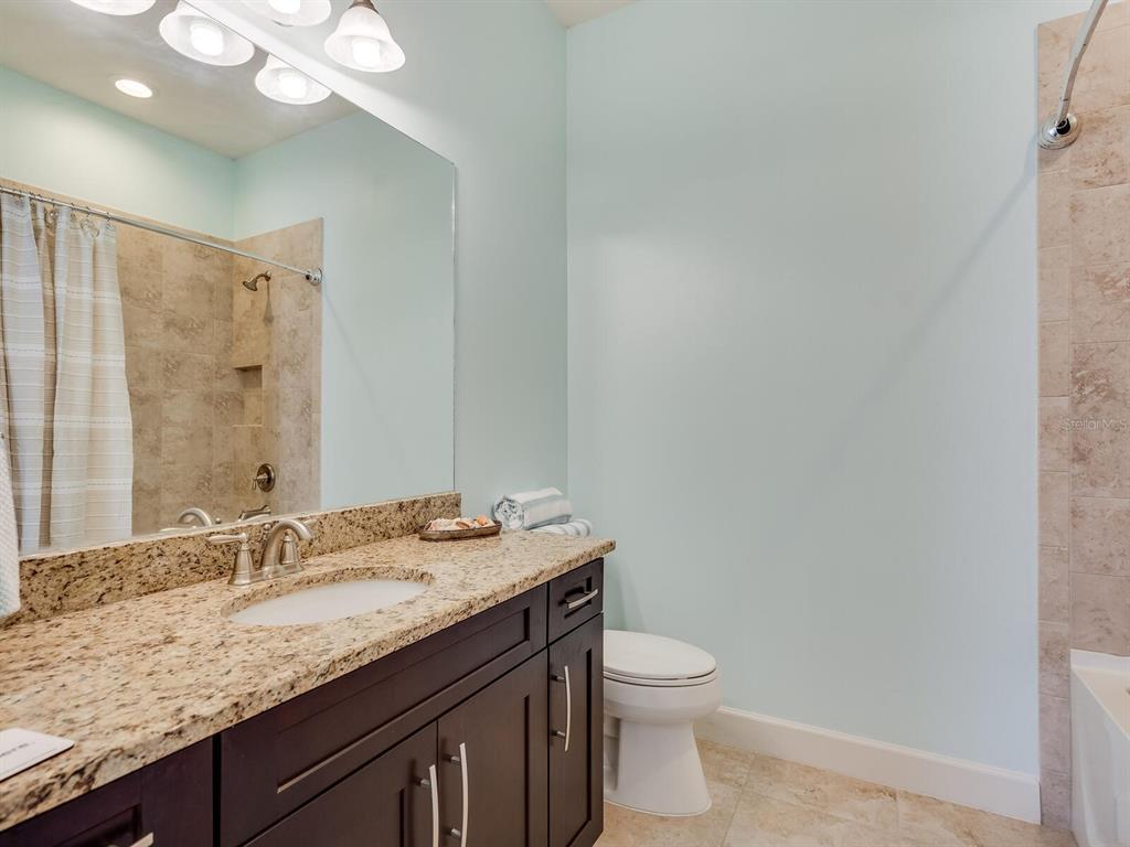 3929 Waypoint Avenue Osprey, FL 34229 - Photo 12 of 56 a bathroom with a granite countertop sink a toilet and a mirror