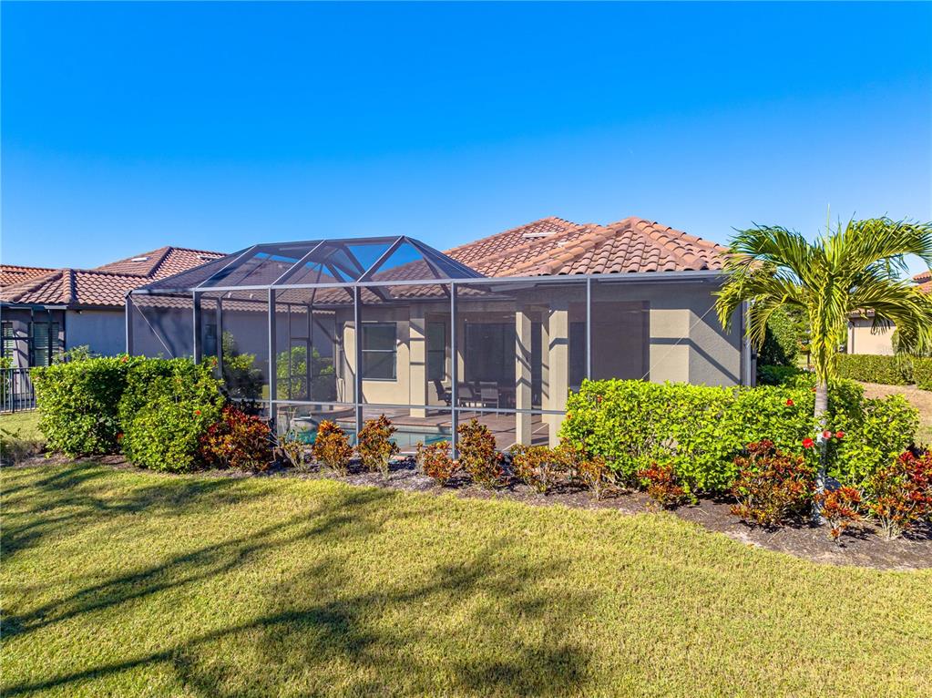 3929 Waypoint Avenue Osprey, FL 34229 - Photo 27 of 56 a front view of a house with a garden and yard