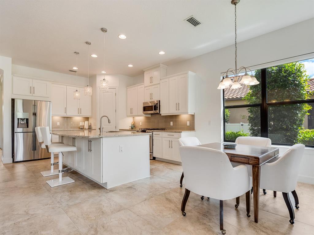 3929 Waypoint Avenue Osprey, FL 34229 - Photo 6 of 56 a dining room with furniture a large window and kitchen view