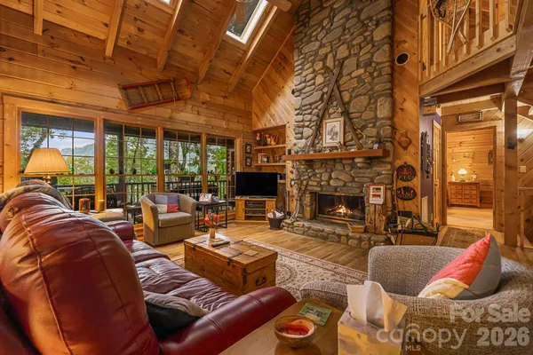 a living room with furniture fireplace and a large window