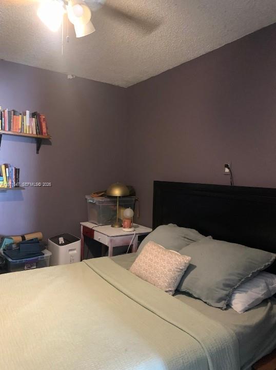 7010 Southwest 103rd Place Miami, FL 33173 - Photo 7 of 10 a bedroom with a bed and a lamp on dresser