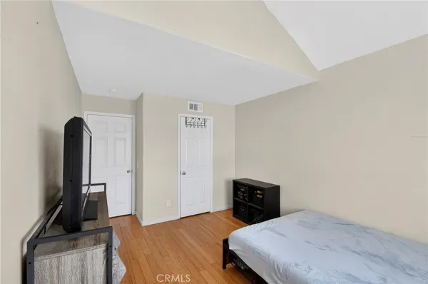 a bedroom with a bed and wooden floor