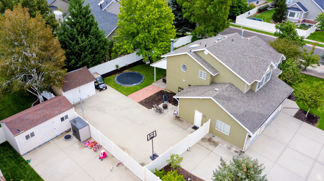 12169 Hidden Valley Road, Unit 44 Sandy, UT 84092 - Photo 47 of 49 Expansive concrete driveway, two detached storage sheds, fenced backyard with a lawn area, and mature trees providing shade