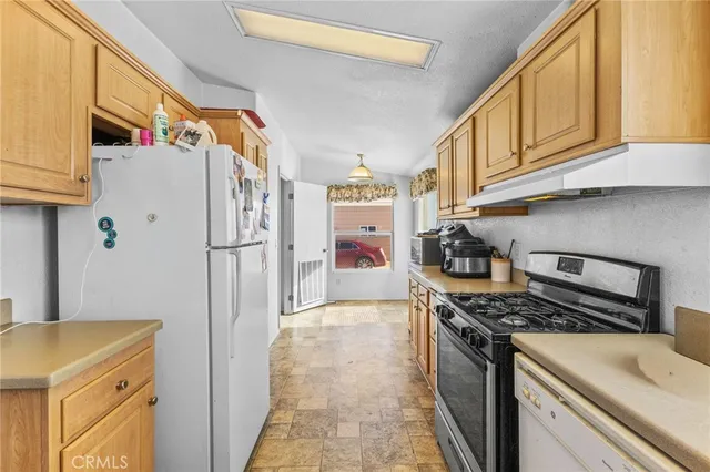 a kitchen with stainless steel appliances granite countertop a refrigerator and a stove